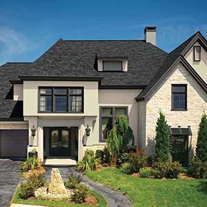 Front view of a typical mid-class home with charcoal black GAF shingles on its roof